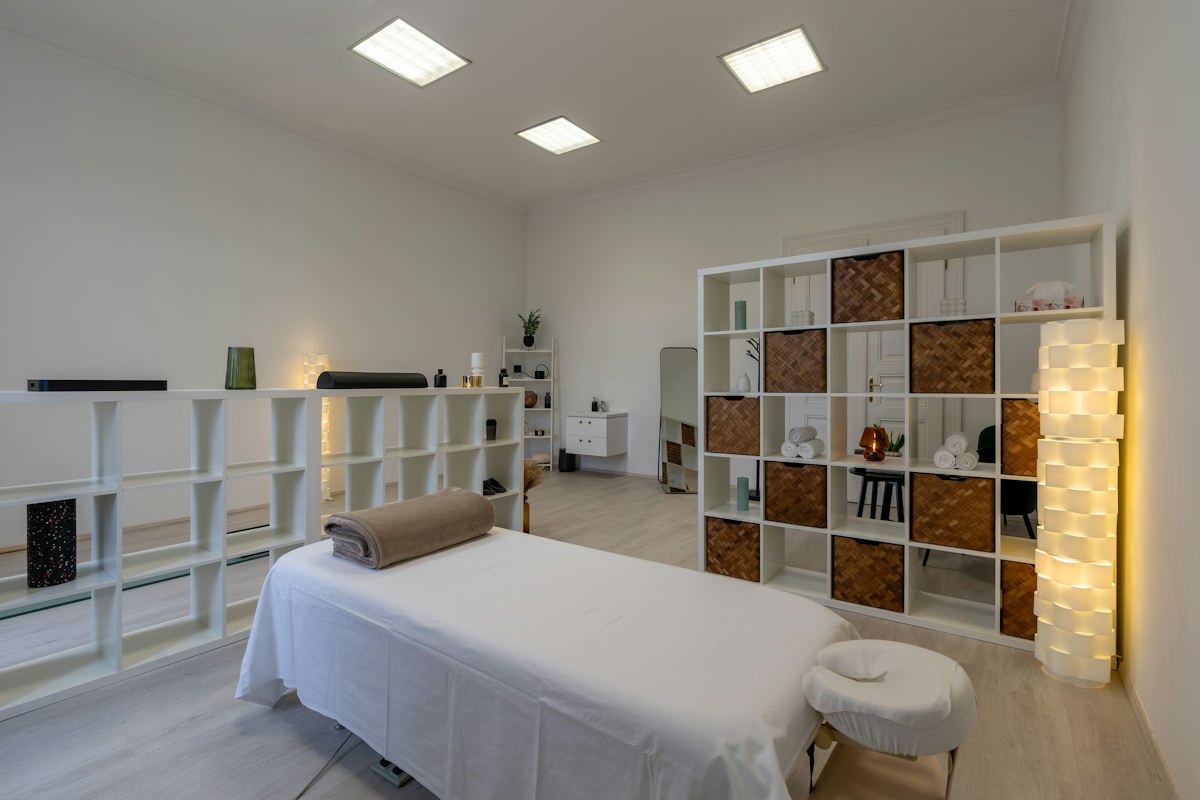 Clean hotel spa treatment room with massage table and towels in a comparison of spa and outcall massage